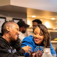 Two guests at event sitting at table and smiling at each other